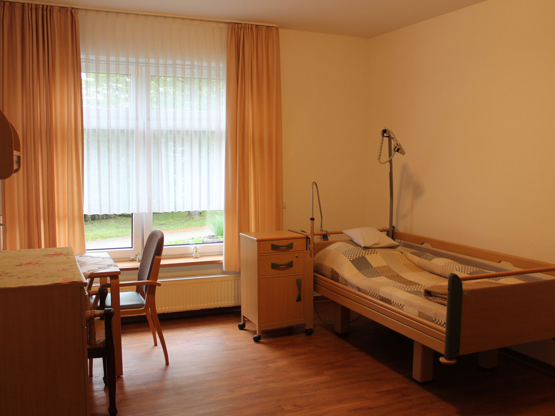 Ein Bewohnerzimmer mit Bett, Schrank und Stuhl.