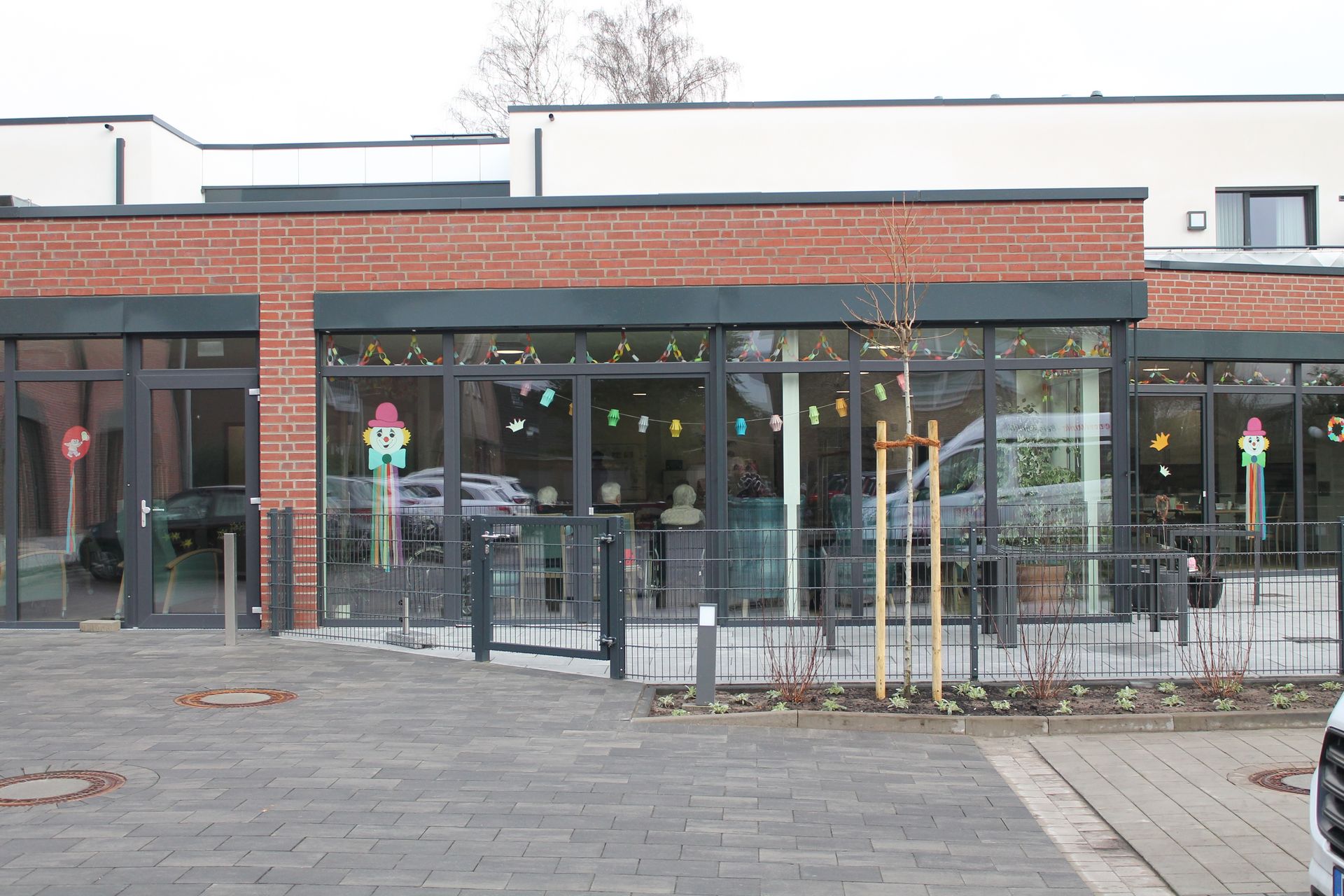 Die Tagespflege von außen. Große Spiegelfront, roter Klinker.