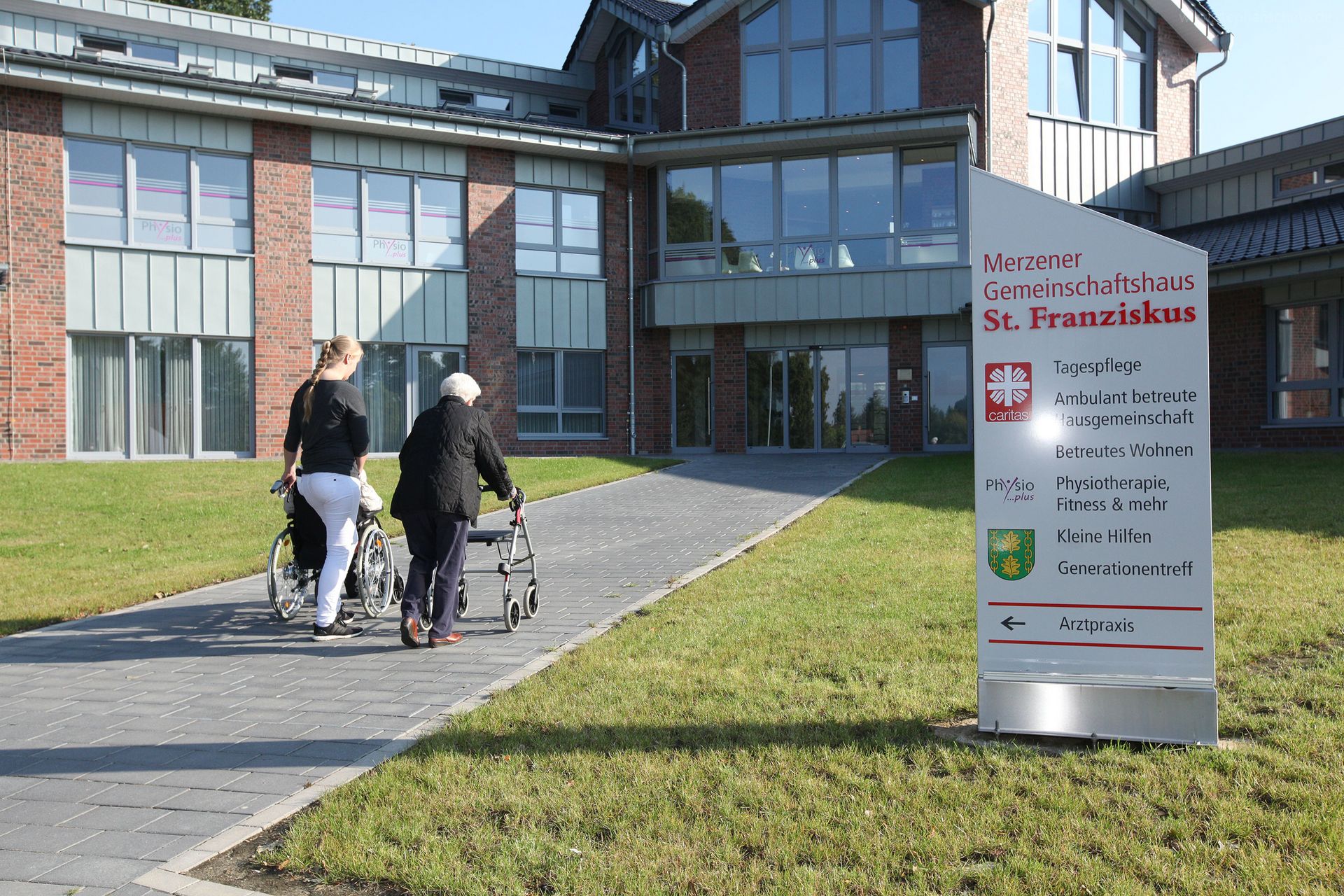 2 Personen, die auf einen Weg zu eine, großen Haus laufen.