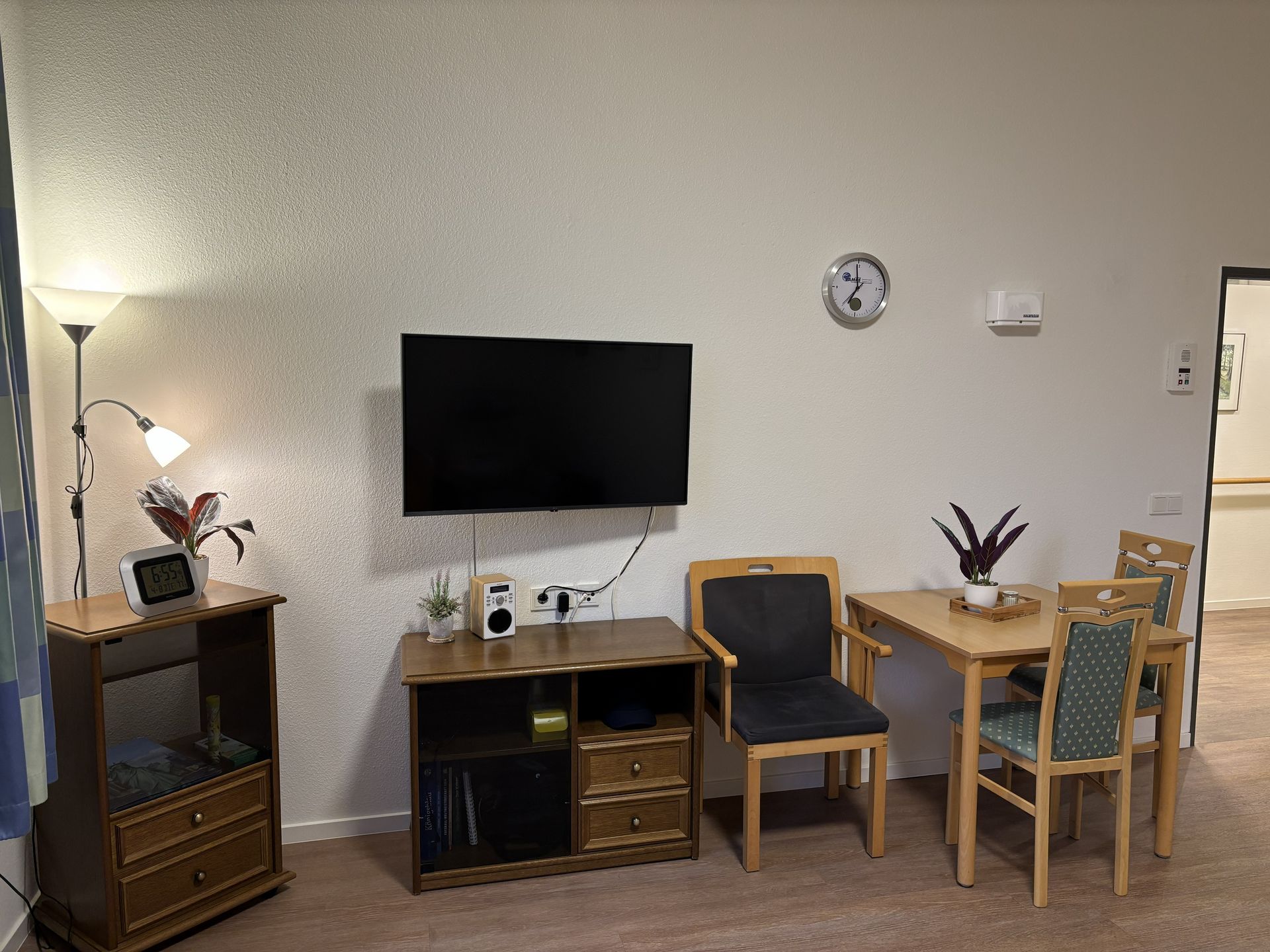 Bwohnerzimmer mit TV, Tisch, Stühle und Sonstiger Deko
