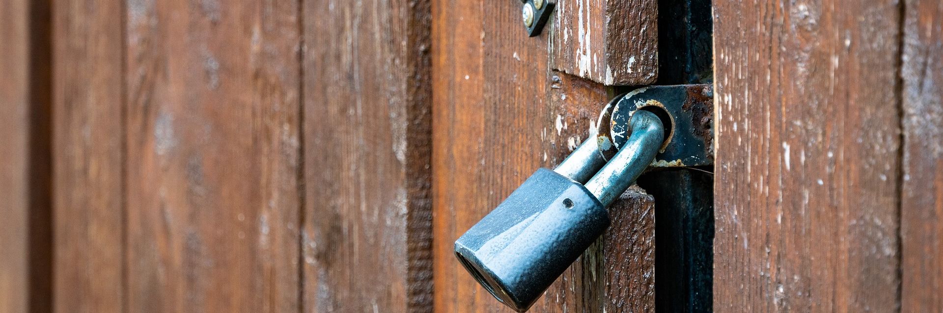 Schwarzes Schloss hängt vor brauen Holztür