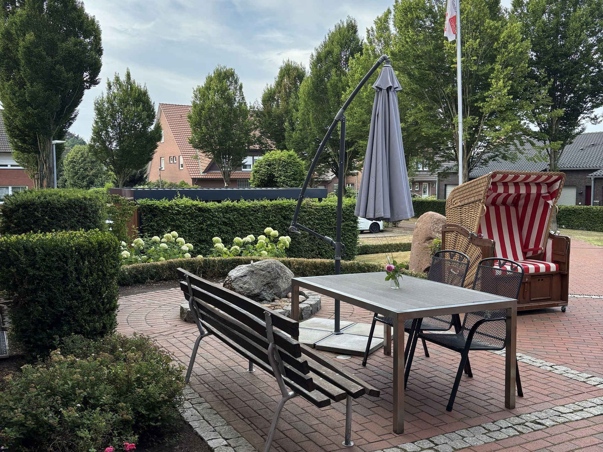 Sitzecke draußen mit Tisch und Stühlen und Sonnenschirm